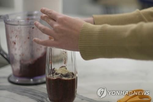 땅콩 알레르기 환자가 스무디에 알레르기 치료제 팔포지아를 섞고 있다. [AP=연합뉴스] 
