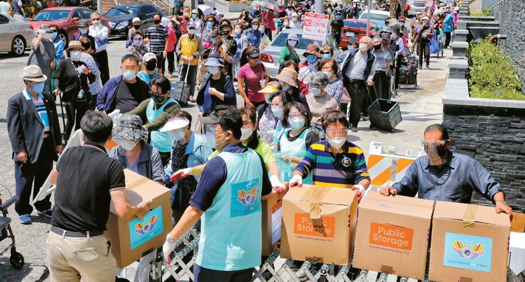 13일 LA한인상공회의소와 한남체인, 허브 웨슨 LA 시의원이 공동으로 마련한 식료품 500상자 무료 배포 행사에 많은 한인들이 몰렸다. 식료품 상자를 나눠주는 웨슨 의원(앞줄 오른쪽)과 하기환 전 상의 회장(앞줄 오른쪽 두번째). [김상진 기자]
