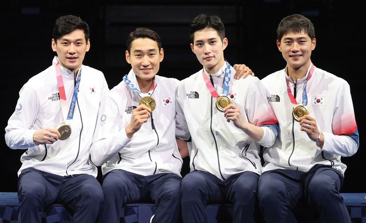 28일 일본 지바의 마쿠하리 메세에서 열린 2020도쿄올림픽 펜싱 남자 사브르 단체전 금메달 시상식에서 (왼쪽부터) 구본길 김정환 김준호 오상욱 선수가 메달을 들고 시상대에 앉아 포즈를 취하고 있다.[연합]