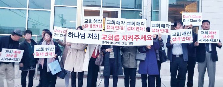 팰리세이드교회 교인 70여 명이 하나가 돼 교회를 지키기 위한 운동을 벌이고 있다. 사진은 최근 교회 해산안건으로 임시 노회가 열렸던 뉴저지소망교회 밖에서 팰리세이드교회 교인들이 피켓을 들고 서 있는 모습.