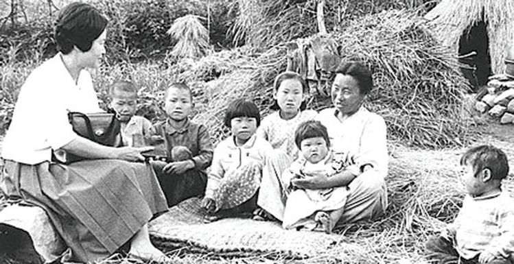  당시 국민학교 입학식 때 ‘앞으로 나란히’를 하고 있는 어린이들(사진 위)). ‘덮어놓고 낳다 보면 거지꼴 못 면한다.’ 정부는 1960년 가임여성 1명당 평균 출생아 수가 6명에 이르자 이듬해부터 산아제한정책을 쳘쳤다. 전국에 가족계획 상담소를 설치하고, 면(面)마다 가족계획 요원을 배치해 지도 계몽에 나섰다. 위 사진은 경기도 포천의 한 가정에서 가족계획 요원이 상담을 하는 장면. 6명의 자녀를 둔 어머니가 상담원으로부터 피임 방법에 관한 설명을 들으며 쑥스러워하고 있다. [김천길 전 AP통신 기자]