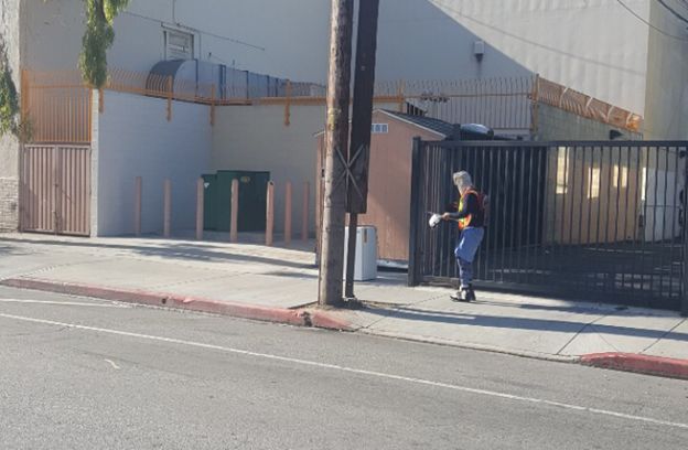 Nearby the school, a sanitation worker in a full suit, cleans with chemicals after the police ordered the homeless people to clear the sidewalks. Source: Author, Joanne Chae
