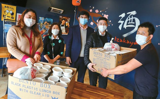 본지의 한인식당 지원 캠페인 ‘점심 한끼’에 참여한 한미은행은 1월 한 달간 전국 35개 지점 직원들에게 주 1회 무료 점심을 제공하기로 했다. 12일 LA한인타운 내 도쿄함바그에서 한미은행의 LA다운타운·버몬트·올림픽점 직원들이 점심을 픽업하면서 환하게 웃고 있다. 김상진 기자