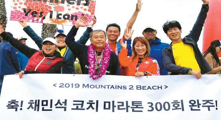 지난 2019년 6월 벤투라 시에서 열린 제9회 마운틴투비치 마라톤 대회에서 통산 300회 마라톤 풀코스 완주 기록을 세운 고 채민석(맨 앞 왼쪽 두 번째) 코치가 포레스트러너스클럽 회원들의 축하를 받고 있다. [중앙 포토]