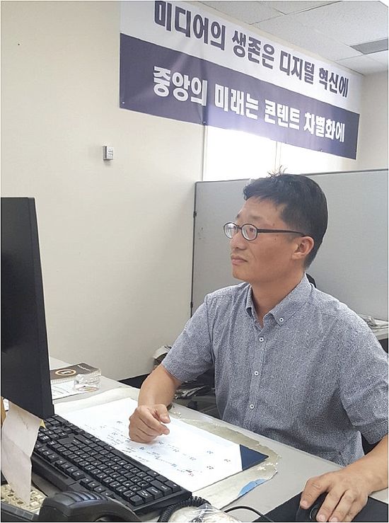 중앙일보에서 30년 이상 몸 담으며 가파른 미디어업계 변화와 디지털 혁신을 경험한 봉화식 부장(전략-디지털팀)이 '미디어의 생존은 디지털 혁신에' 플래카드 아래서 인터넷으로 기사 자료를 검색하고 있다. 사진 김준우 기자