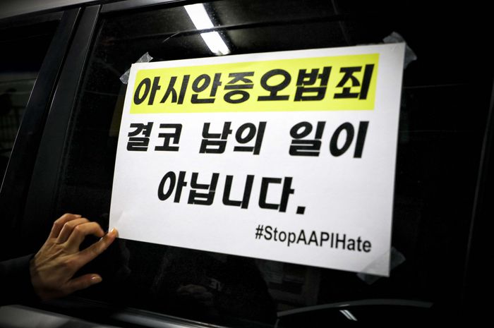 차량시위 출발전 시위참가자들이 차량에 인종차별반대 구호가 적힌 스티커를 부착하고 있다. 
