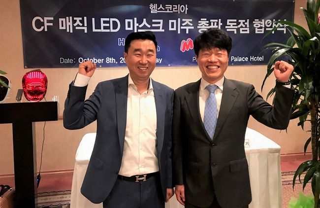 헬스코리아 은영기 대표(왼쪽)와 CF LED 매직 마스크 하덕용 대표가 미주 총판 독점 협약식을 맺고 화이팅을 외치고 있다 