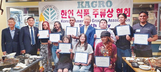 사우스베이 식품상협회가 25일 10명의 고객 자녀들에게 장학금을 전달했다. 협회 임원들과 장학생들이 함께 포즈를 취했다. [사우스베이 식품상협회 제공]