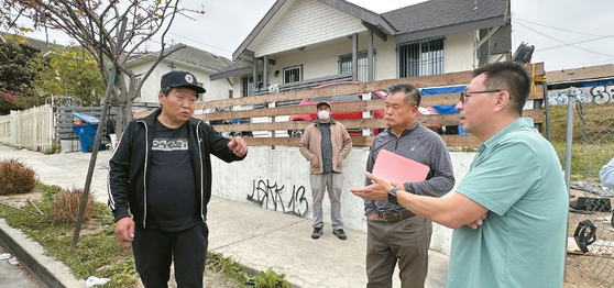 노숙자 임대주택에 장기 거주 중인 박현(왼쪽) 씨가 KYCC 릭 김(맨 오른쪽) 디렉터와 의견을 나누고 있다.   김상진 기자