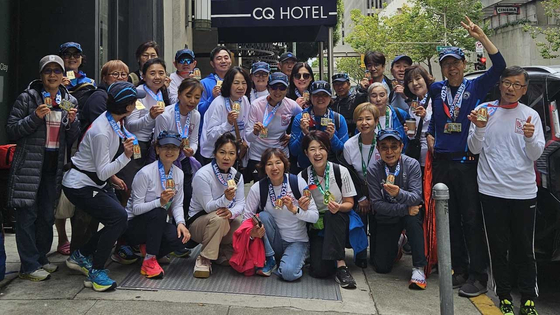 샌프란시스코 마라톤 대회를 마친 소캘러너스 회원들이 숙소 앞에 모였다. 맨 앞줄 앉은 이들 중 오른쪽 끝이 하프 코스 65~69세 디비전 1위에 오른 김중용 회원. [소캘러너스 제공]