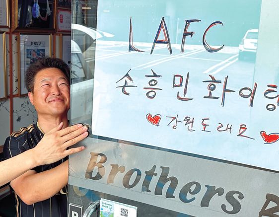 형제갈비 주부권 대표가 손흥민 응원 문구 포스터를 부착하고 있다. 김상진 기자 