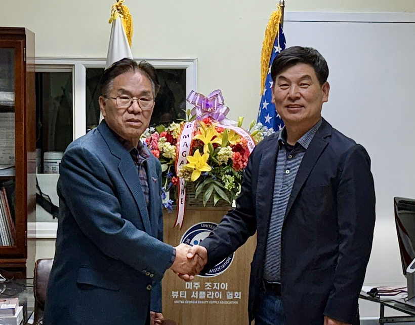  나상규 NFBS 회장과 손영표 미래뷰티 회장이 27일 밤 통합에 합의한 뒤 악수하고 있다.