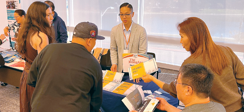 김경준 기자(가운데)가 본지의 미디어 키트를 나눠주며 소수계 언론의 중요성에 대해 설명하고 있다. [ACoM 제공]