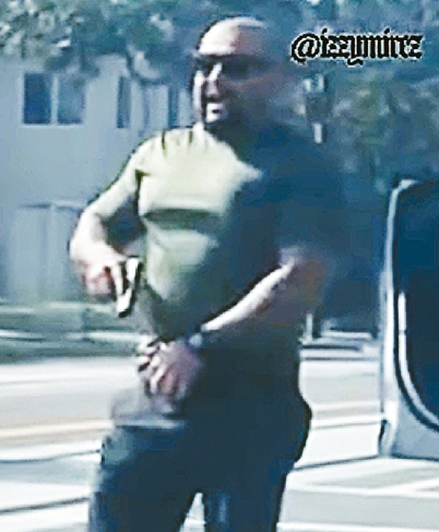 지난 9일 오후 샌타애나의 한 교차로에서 민간 복장을 한 ICE 요원이 시민을 향해 총을 겨눴다.  [@easymike/X캡처]