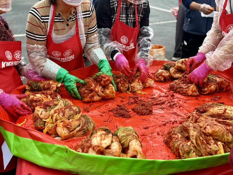 남녀노소 모여 절인 배추에 속을 버무리고 있다.