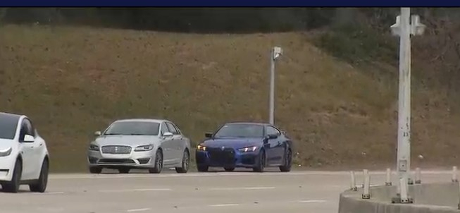 차들이 달리는 공항 옆 도로 갓길에 차 두 대가 주차돼 있다. [채널2액션뉴스 보도영상 캡처]