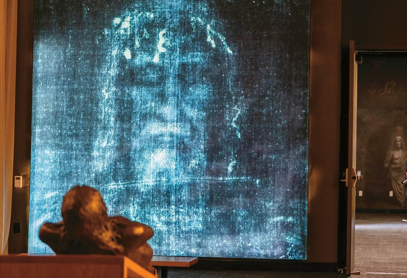 토리노 수의의 얼굴 부분 네거티브 사진 앞에 예수의 청동 조각상이 놓여 있다. [알렌 샤벤/ LA타임스]