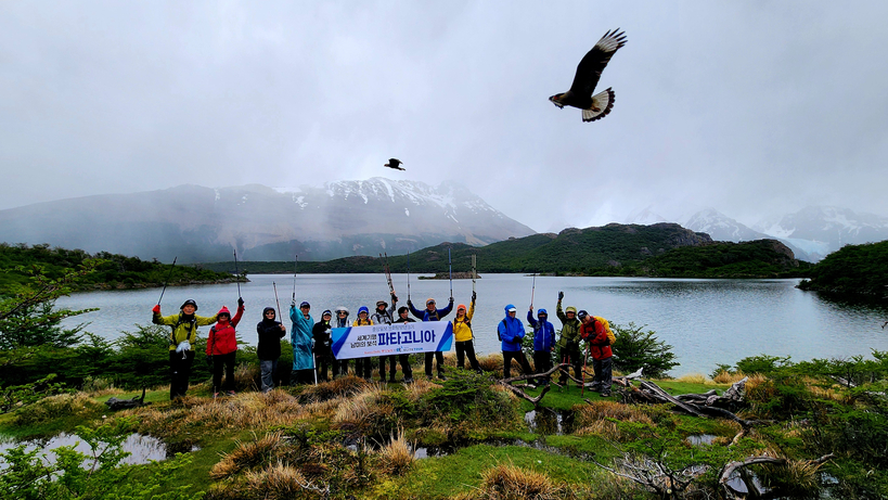 때마침 카라카라 새가 날아가는 나구나 카프리 호수를 배경으로 기념촬영