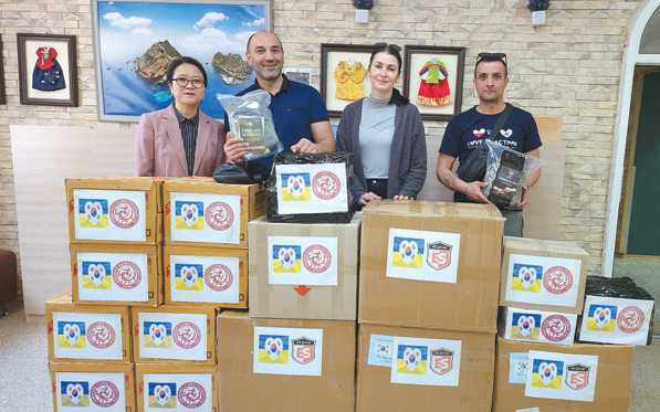 화랑인터내셔널이 전달한 1만여 개의 의료키트 상자를 배경으로 우크라이나 자원봉사자들이 기념 촬영하고 있다. [화랑인터내셔널 제공] 