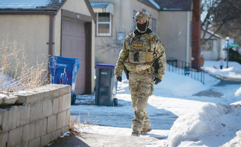 지난달 28일 미네소타주 세인트폴의 헤이즐 파크 커뮤니티에서 국토안보부 요원이 눈이 내린 거리를 지나가고 있다. [제라노 몰리나, 에릭 세이어/LA타임스]