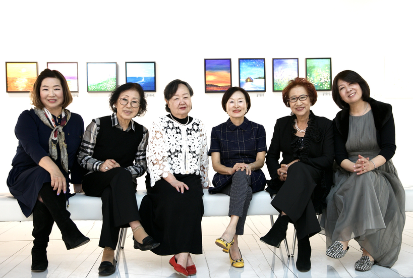 'Grida 힐링 아트클래스' 1주년 기념 전시회 참가자들과 AJL 아트 갤러리에 전시된 작품들.