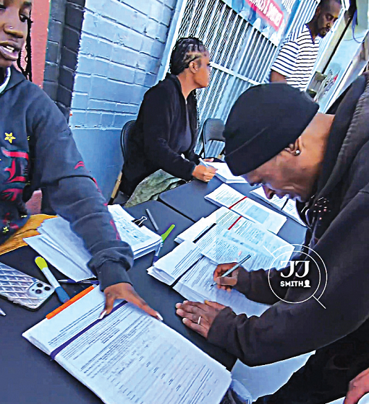 유권자로 추정되는 사람들이 테이블 위에 놓인 서류에 서명하고 있다. [X 캡처]