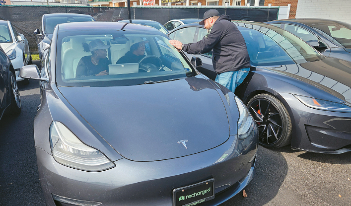 한 중고차 딜러십에서 고객들이 테슬라 차량을 둘러보고 있다. [로이터]