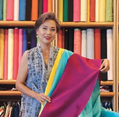 이화웨딩앤한복 로라 박 대표가 ‘골든(Golden)’ 축하 공연 의상에 사용된 한복 원단에 관해 설명하고 있다. 김상진 기자