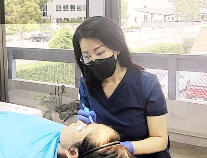 샤론 여 원장이 고객의 얼굴형과 눈썹 결에 맞 춘 자연눈썹 시술을 진행하고 있다.