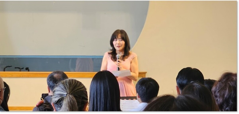 사진=안젤리나 박 밴쿠버 여성회 회장이 ‘러브 콘서트’에서 인사말을 전한 뒤 싱글맘 가족들의 이야기를 소개하고 있다. 