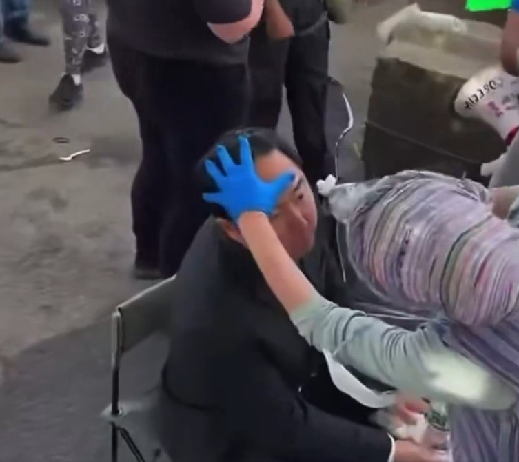 지난 25일 뉴저지 델라니홀 이민자 구금시설 앞 시위 현장에서 한 자원봉사자가 ICE 요원들이 사용한 최루 스프레이에 노출된 앤디 김 연방상원의원의 눈을 물로 씻어주고 있다. [X]
