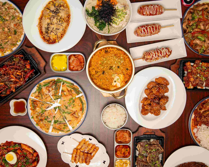 김스 키친의 대표 메뉴들. 불고기, 비빔밥, 김밥, 떡볶이, 한국식 핫도그, 파전 등 정통 한식과 현지 입맛을 반영한 메뉴가 한 상 가득 차려져 있다. [김스 키친 제공]