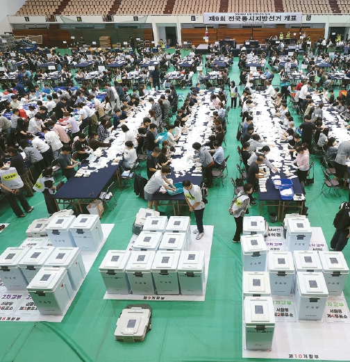 6·3지방선거일인 지난 3일(한국시간) 서울 관악구 서울대 체육관에 마련된 개표소에서 수많은 사무원들이 개표 작업을 하고 있다. [연합뉴스]