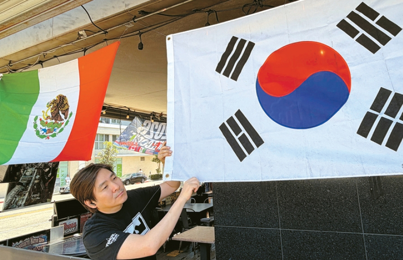 17일 아사도포차 천기범 사장이 패티오에 태극기와 멕시코 국기를 달고 있다. 김상진 기자