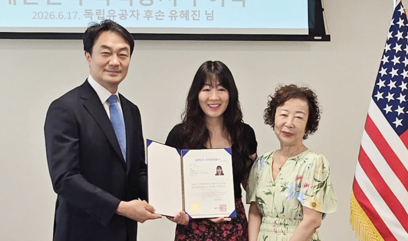 지난 17일 뉴욕총영사관 회의실에서 김상호 뉴욕총영사(왼쪽)가 국가유공자 후손인 유혜진 씨에게 대한민국 국적증서를 수여하고 있다.  [사진 뉴욕총영사관]