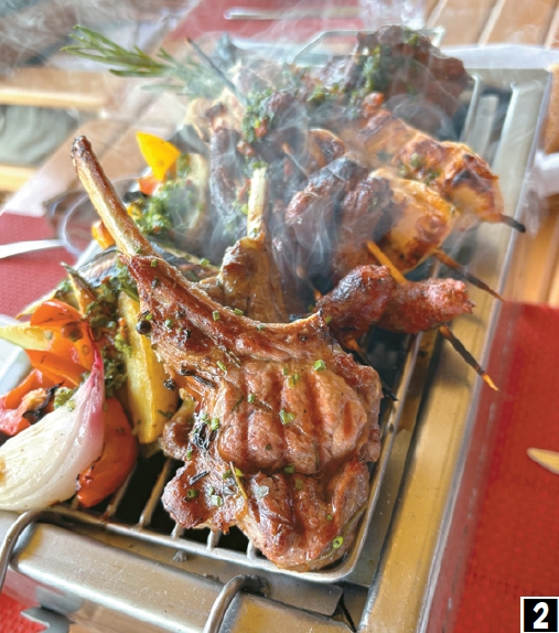 3. 숯불 위에서 갓 구워낸 양갈비와 양꼬치 요리. 향긋한 허브와 구운 채소를 곁들여, 모로코식 육류 요리 특유의 진한 풍미와 현장감 있는 식사를 보여준다.