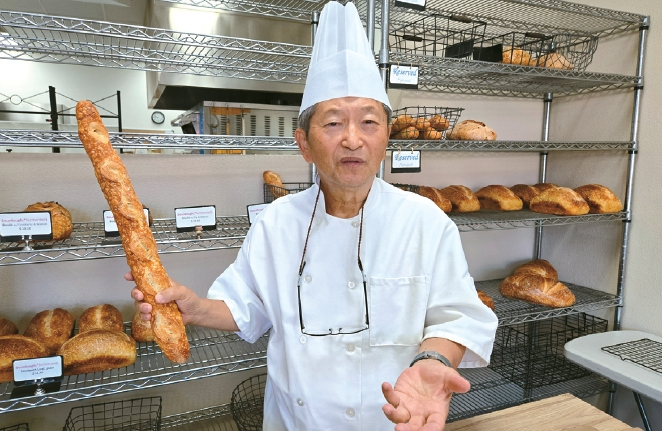 모세 빵집의 권오근 대표가 직접 만든 사워도우 바게트를 들고 빵에 대해 설명하고 있다.