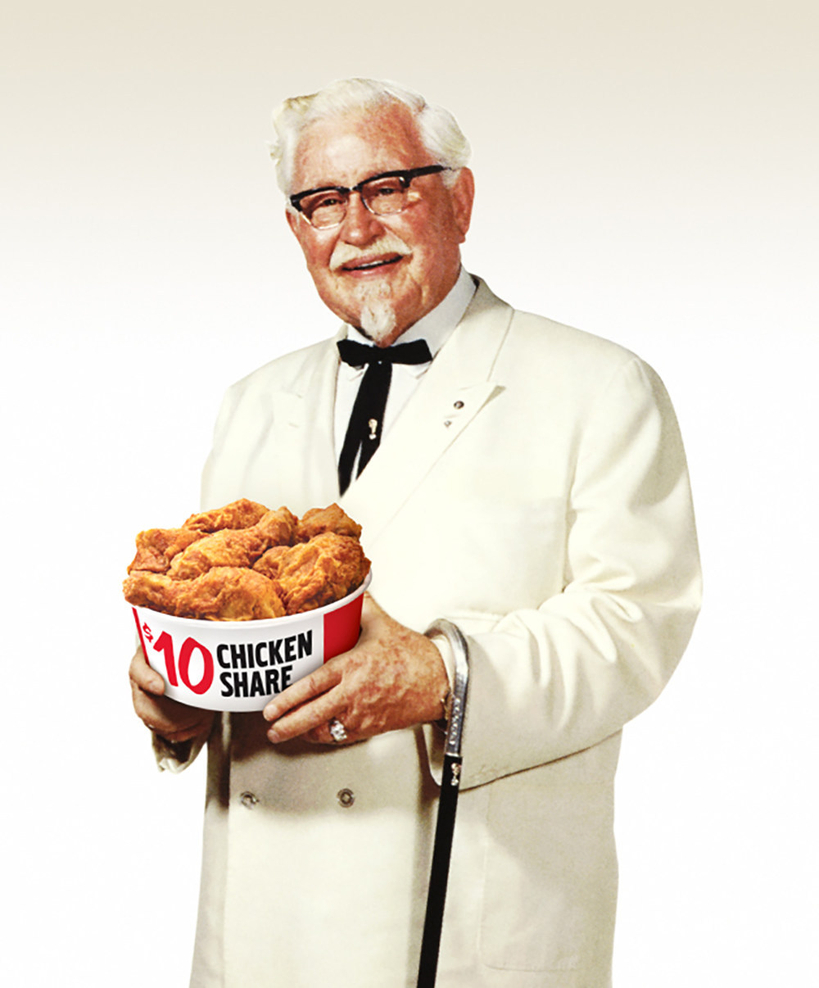 KFC 창업주 할랜드 샌더스가 흰색 정장과 검은 나비넥타이를 착용한 채 치킨 버킷을 들고 포즈를 취하고 있다. 샌더스의 유품과 자택, 레스토랑 등이 공개 경매에 부쳐지면서 다시 주목받고 있다. [KFC]