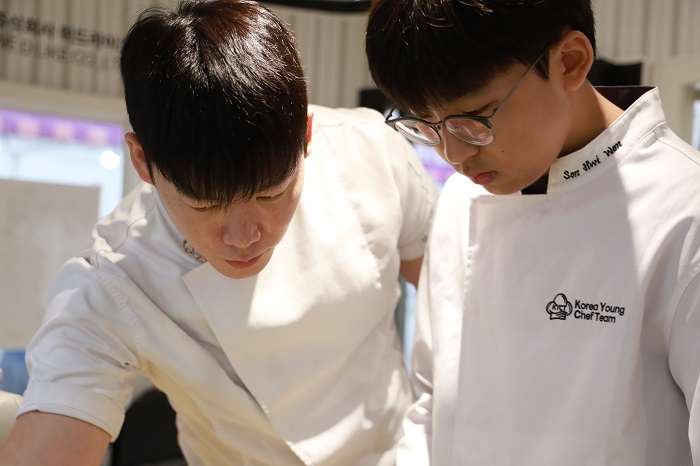 [Chef Woo Youl Jo guiding young chef Hwi Won Son on-site (Provided by KYCT Reporter Mun Su Kim, Photo Journalist Hyun Ho Lee)]