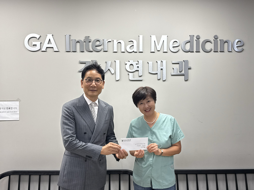 김 원장의 부인이 박은석 한인회장에게 성금을 전달하고 있다. 