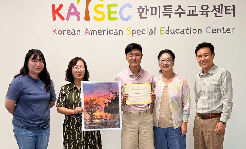 레이먼드 김 작가가 한미특수교육센터(소장 로사 장, 이하 센터) 개최로 최근 더 소스 몰에서 열린 '드림아트 콘테스트' 전시회에서 관람객들이 선정한 '피플스 초이스 어워드'를 받았다. 발달장애인의 예술적 재능 발굴을 위해 열린 콘테스트에 초대 작가로 참여한 김 작가는 '풀러턴의 석양'이란 작품으로 수상했다. 레이먼드 김(가운데) 작가가 상장을 들고 있다. 김 작가 왼쪽 작품을 든 이는 로사 장 소장. [센터 제공]