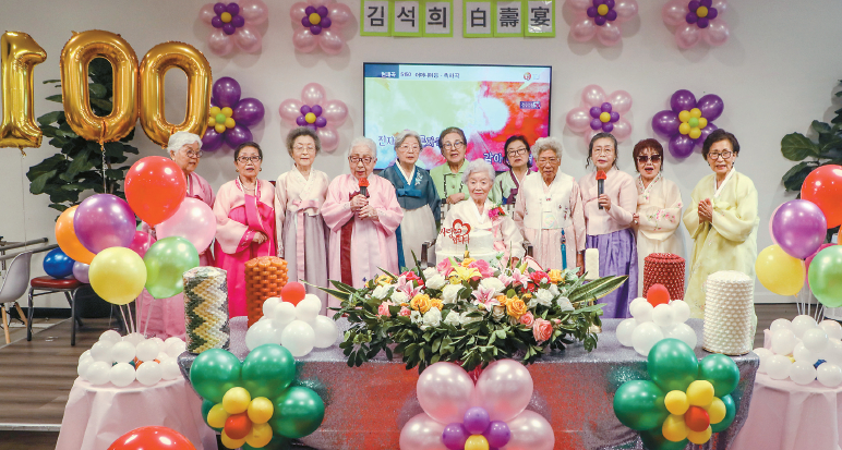15일 100세 생일을 맞은 김석희(가운데) 할머니가 보건센터 회원들의 축하 노래를 들으며 환하게 웃고 있다. 한복을 곱게 차려입은 지인들이 무대에 함께 올라 김 할머니의 장수를 축하했다. 김상진 기자