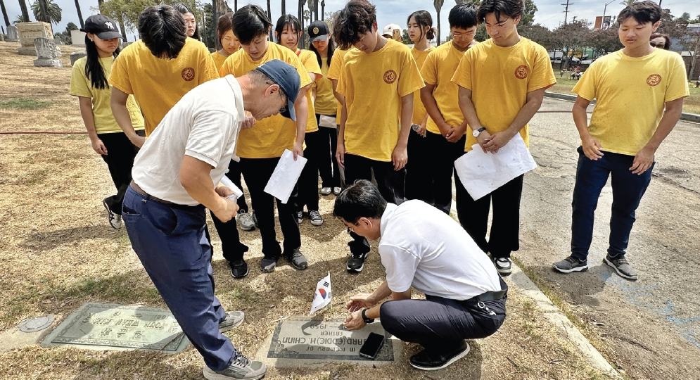 지난 23일 오전 화랑청소년재단 소속 학생들과 학부모들이 로즈데일 묘지에서 독립유공자 신형호 지사의 묘비를 찾아냈다. 박윤숙(앞줄 오른쪽)과 샘신(앞줄 왼쪽) 목사가 묘비에 적힌 이름과 생년월일을 확인하고 있다. 김상진 기자