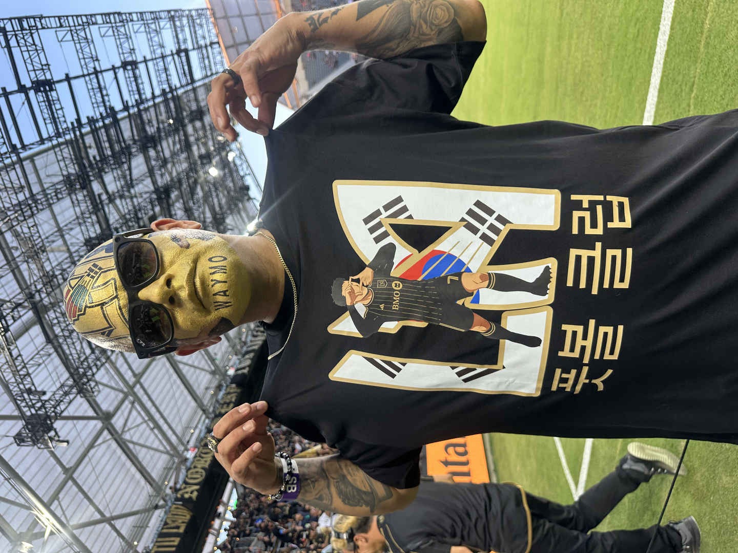 LAFC 팬이 본지 기자에게 손흥민의 찰칵 세리머니 모습과 ‘풋볼 클럽’이라고 적힌 티셔츠를 보여주고 있다.