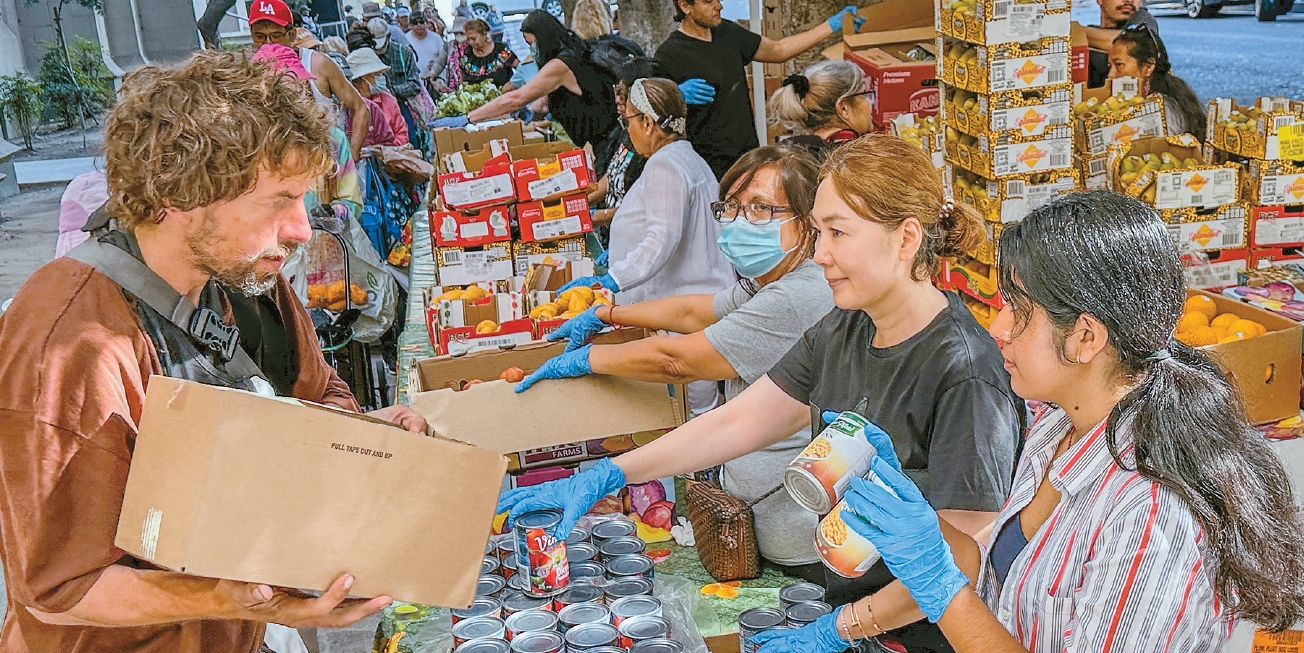 지난달 29일 오전 LA한인타운에 있는 임마누엘 장로교회 앞에서 자원봉사자들이 식료품을 나눠주고 있다. 이곳에서는 매주 수요일과 금요일 오전 푸드뱅크 행사가 진행된다.  김상진 기자