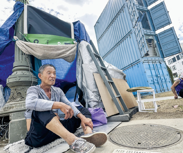 지난 10일 LA 한인타운 후버와 윌셔가 교차하는 거리. 한인 곽동천 씨가 홈리스 셸터 인근 자신의 텐트 앞에 앉아 있다. 이곳에는 LA시가 컨테이너를 개조한 임시 셸터가 운영 중이다. 곽 씨는 “밤에는 셸터에서 잠을 자지만 조리시설이 없어 한식을 직접 해먹기 위해 대부분의 시간을 텐트에서 보낸다”고 말했다. 김상진 기자