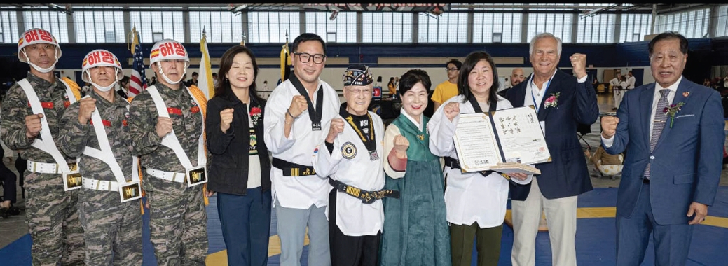 그레이스 멩 연방하원의원(민주·뉴욕 6선거구·오른쪽 세 번째)이 론 김 뉴욕주하원의원(민주·40선거구·왼쪽 5번째) 추천으로 ‘2025 뉴욕오픈 태권도 챔피언십’에서 격파를 한 후 국기원 명예 7단증을 받았다. [대뉴욕지구태권도협회]