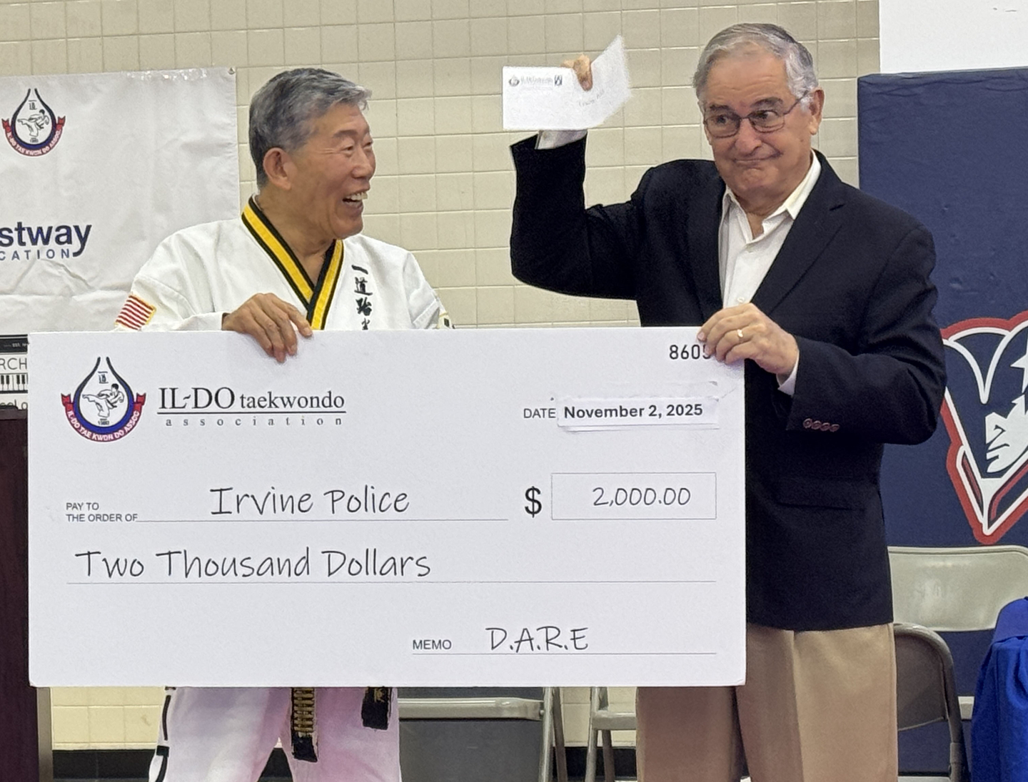 강창진(왼쪽) 관장이 래리 에이그런 어바인 시장에게 청소년 약물방지 프로그램 기금 2000달러를 전달하고 있다. [일도태권도 제공]