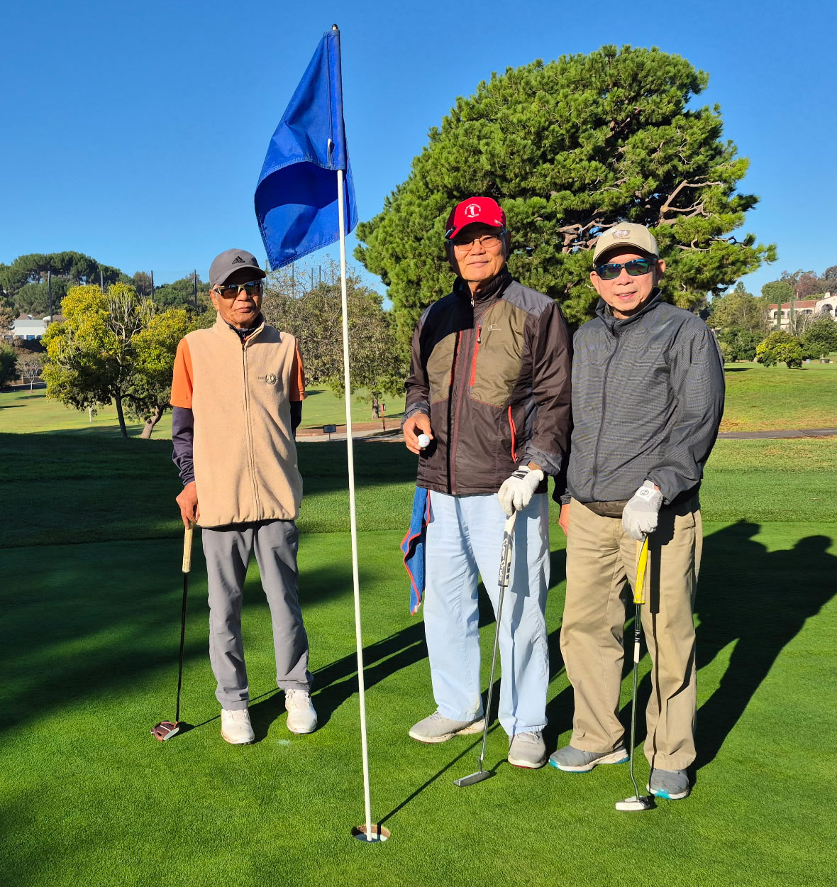 지난달 20일 라구나우즈 골프장 2번 코스 8번 홀에서 김은식(가운데)씨가 홀인원에 성공한 직후 홀컵에서 꺼낸 공을 보여주고 있다. [김진모씨 제공]