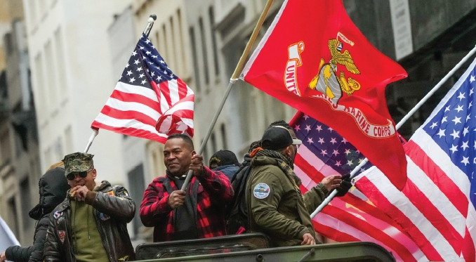 11일 뉴욕시 맨해튼에서 열린 제105회 베테란스데이 퍼레이드에서 참전용사들이 탑승한 차량이 성조기와 군기를 휘날리며 행진하고 있다. 에릭 아담스 시장도 현장에 참석해 참전용사들의 헌신을 기렸으며, 캐시 호컬 뉴욕주지사는 퍼레이드에 앞서 참전용사 지원 강화를 위한 법안에 서명하고 주 차원의 복지 확대를 강조했다.  [뉴욕주지사실]